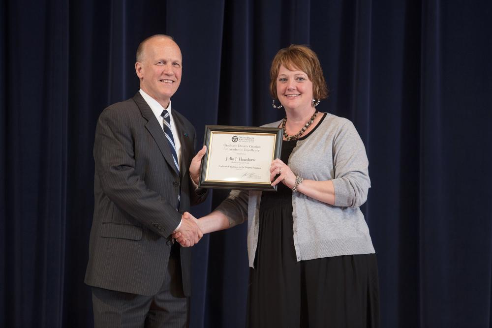 Doctor Potteiger posing for a photo with an award recipient in a black dress and grey sweater